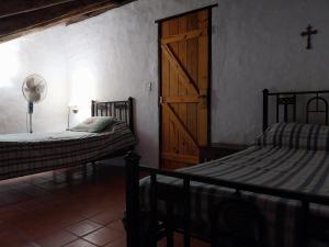 圣米格尔·德·图库玛Casa de campo en tafi del valle的一间卧室设有两张床和木门