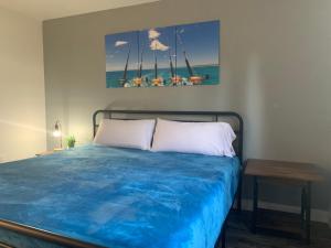 BrownsvilleBrownsville Motel的一间卧室配有一张带蓝色床单的床和一张桌子。