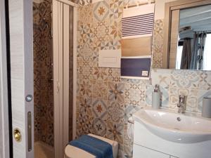 希拉Villa Bella Sera的一间带水槽、卫生间和镜子的浴室