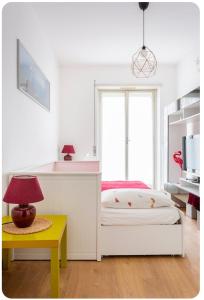 米兰Casa Rizzoli - bilocale vicinissimo M2的一间卧室配有一张床和一张带台灯的桌子
