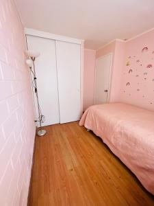 拉塞雷纳Casa Piacenza, Cerca De Mall y Faro La Serena的卧室配有粉红色的床和灯
