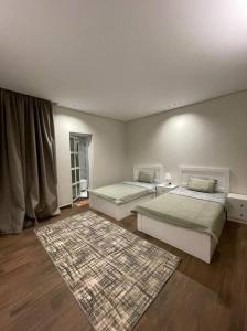Yanbu Al Bahrشاليه رحال的一间带两张床的卧室和地毯