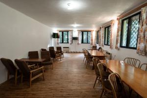 多克西Penzion a Restaurace Kamínek的用餐室设有桌椅和窗户。