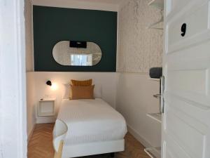 拉拉古纳Room27的一间小卧室,配有一张床和镜子