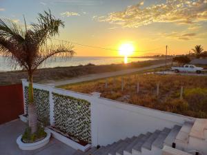 San CarlosPuerto San Carlos Bay House & Tours -1st Floor-的棕榈树海滩上的日落