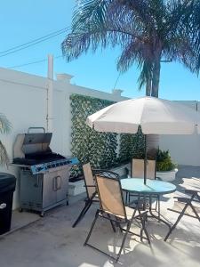 San CarlosPuerto San Carlos Bay House & Tours -1st Floor-的一个带烧烤架和桌椅的庭院