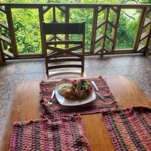 Benque Viejo del CarmenLa Hacienda Belize Guest House的坐在桌子上的一盘食物,椅子