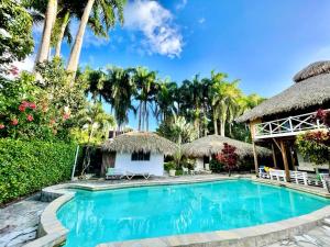 喀巴里特EverGreen Cabarete的棕榈树度假村内的游泳池