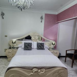 开罗Comfortable Apartment in sheraton Heliopolis 5 minutes from Cairo Airport的一间卧室配有一张大床和一个吊灯。