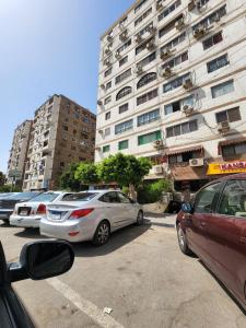 开罗Comfortable Apartment in sheraton Heliopolis 5 minutes from Cairo Airport的停车场,停车场停在高楼前