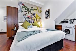 HanwellCharacter and Style Studio - Sleeps 3的一间卧室配有一张床和洗衣机
