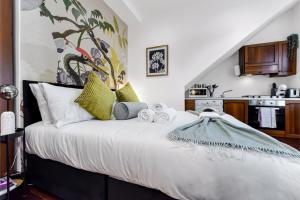 HanwellCharacter and Style Studio - Sleeps 3的卧室配有带绿色枕头的大型白色床