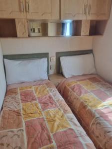 斯凯格内斯Sunrise Holidays Skegness - Emerald的两张睡床彼此相邻,位于一个房间里