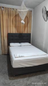 曼克拉La casa de Joan的一间卧室配有一张带白色床单的床和一扇窗户。
