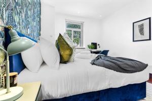 HanwellEnchanted Oasis: A Cozy Flat w/ Botanical Charm的卧室配有带枕头的白色床