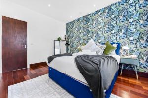 HanwellEnchanted Oasis: A Cozy Flat w/ Botanical Charm的一间卧室配有蓝色的床,拥有蓝色和绿色的墙壁