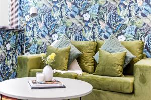 HanwellEnchanted Oasis: A Cozy Flat w/ Botanical Charm的客厅配有绿色沙发和桌子