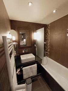 蒙彼利埃Studio haut de gamme sur golf proche Montpellier的一间带水槽、浴缸和卫生间的浴室