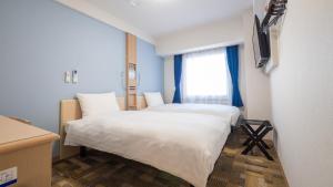 北九州Toyoko Inn Kokura-eki Kita-guchi的小型客房 - 带2张床和窗户