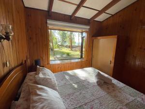 拉恩塞纳达Cabañas Vista al Lago的一间带床的卧室,位于带窗户的房间内