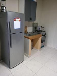 CabraSerenity Zambrano Inn的厨房配有不锈钢冰箱和水槽