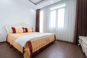 海防The Peninsula Haiphong的一间卧室设有一张大床和大窗户