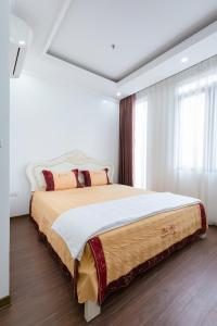 海防The Peninsula Haiphong的卧室配有一张带白色墙壁的大床