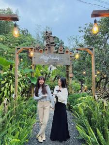Buôn EnaoKim Đồng homestay的两个女人在花园里的小路前行