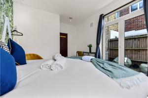 HanwellLovely 2-bedroom rental unit in Greater London的卧室配有白色床和毛巾