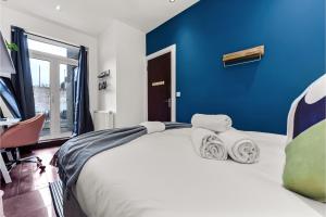 HanwellLovely 2-bedroom rental unit in Greater London的一间卧室设有一张蓝色墙壁的大床