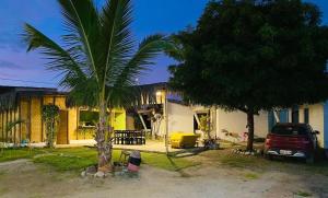 曼克拉Pascana Casa Playa的前面有棕榈树的房子