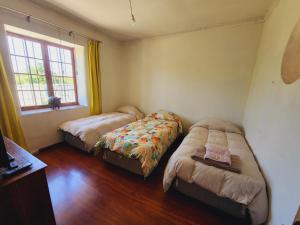 PeñaflorCasa de Campo en Malloco的一间卧室设有两张床和窗户。