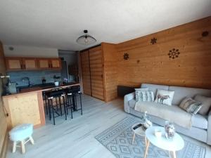 圣米舍德谢洛Appartement montagne LE FLOCON的带沙发的客厅和厨房