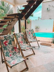 普雷亚Villa Fortal Preá的两把椅子坐在泳池旁的庭院