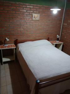 库拉布罗切罗镇los nidos habitaciones的一间卧室配有一张床和两张带台灯的桌子。