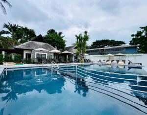 查汶Baan Haad Ngam Boutique Resort的度假村内的一个蓝色海水游泳池