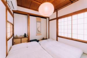 东京One Harajuku: Private Oasis的带窗户的客房内的两张床