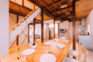 东京One Harajuku: Private Oasis的一间用餐室,配有带白色板的木桌