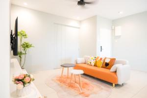 大山脚Zenstay Sdn Bhd的客厅配有橙色沙发和凳子