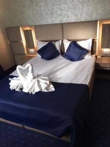 AfumaţiLe Mer的一张配有蓝色和白色床单及枕头的大床