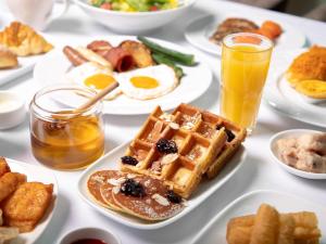 儋州海南海花岛希尔顿酒店的一张桌子,上面放着华夫饼、鸡蛋和其他早餐食品