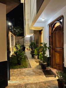 库斯科Allincay Cusco Apart Hotel的走廊上设有盆栽和木门