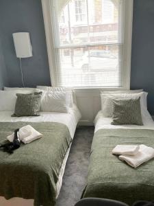 伦敦Comfy Private Bedrooms near Euston, Central London (127)的两张床位于一个房间窗户旁