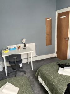伦敦Comfy Private Bedrooms near Euston, Central London (127)的客房设有书桌、床、桌子和椅子。