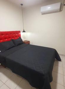 塔里哈Apartamento céntrico Frida's todo nuevo的一间卧室配有一张黑色床和红色床头板