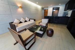 罗勇Serene Phla Resort and Restaurant的客厅配有沙发和桌子