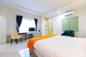 泗水Sans Hotel 88 Andalan Surabaya by RedDoorz的卧室配有一张床、一张桌子和椅子