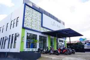 MartapuraUrbanview Hotel Ratu Elok Syariah Banjarbaru by RedDoorz的停在大楼前的一组摩托车