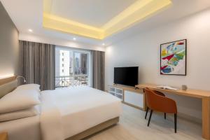 多哈Marriott Executive Apartments City Center Doha的酒店客房配有一张床、一张书桌和一台电视。