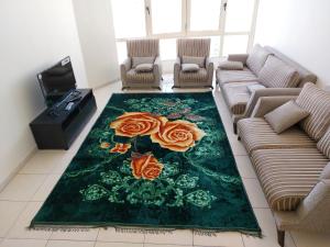 迪拜PRIVATE ROOM FOR BUSINESS EXECUTIVES BY MAUON TOURISM的客厅里有一个绿色的地毯,上面有玫瑰花